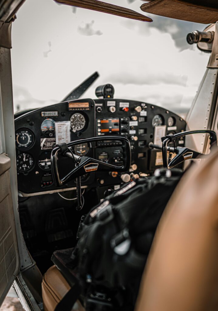 Control panel and yokes of modern light aircraft parked on aerodrome under cloudy sky