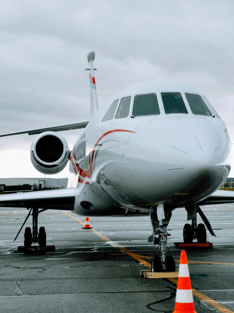 A sleek modern jet aircraft parked on the runway at Grenoble airport, France under cloudy skies.