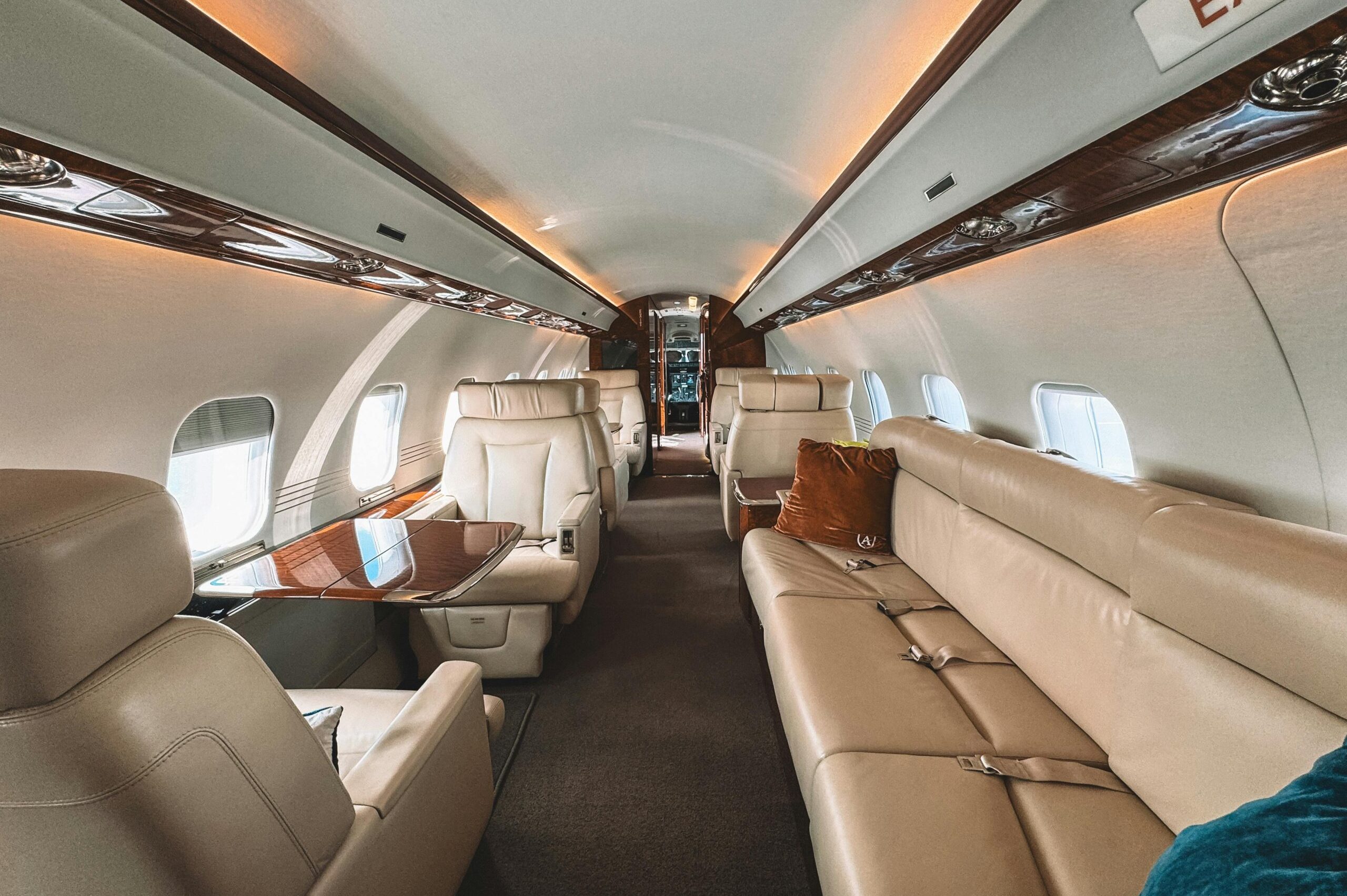 Explore the luxury of a private jet interior featuring leather seats and wooden trim, perfect for exclusive travel.